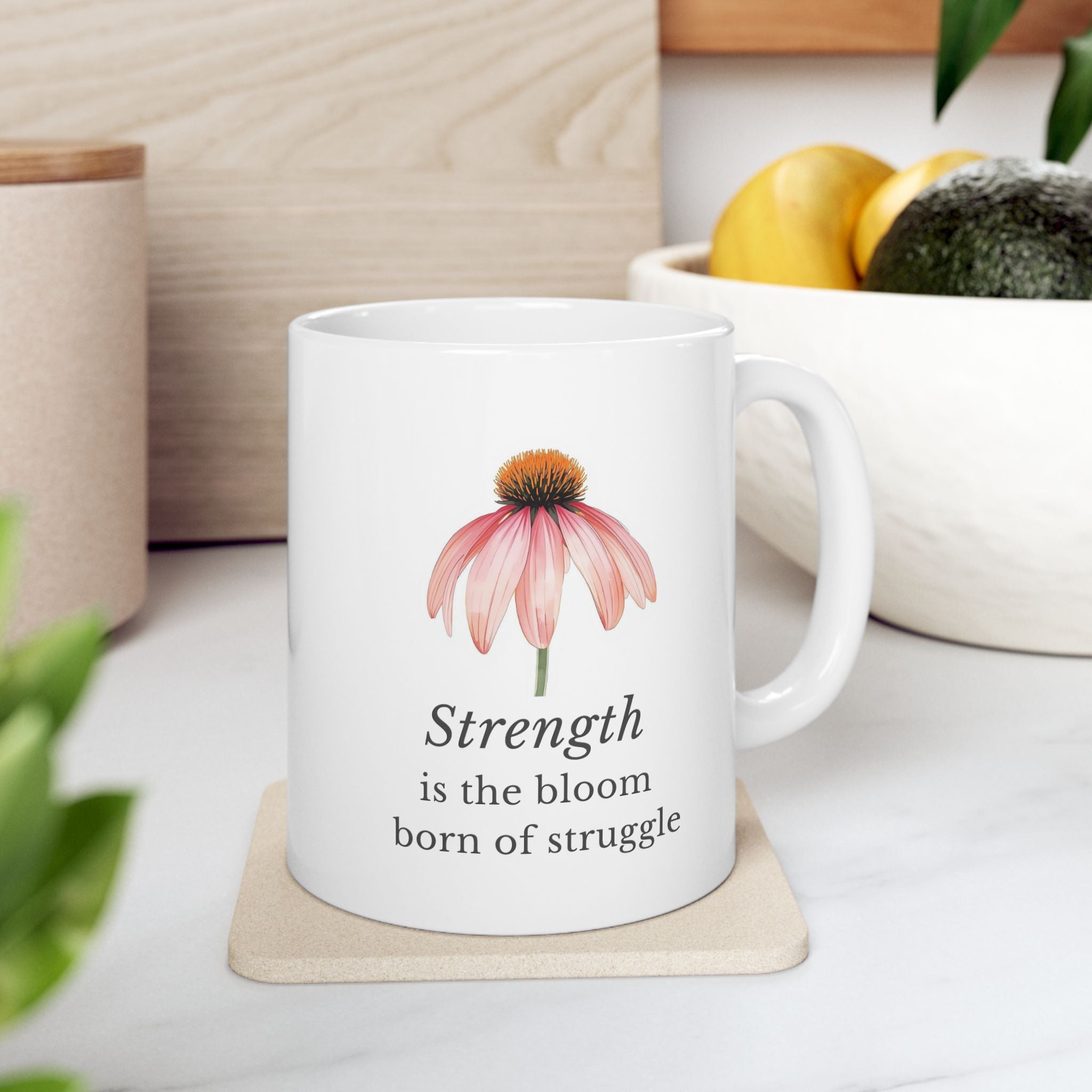 White ceramic mug with a echinacea drawing and motivational quote on a white surface.