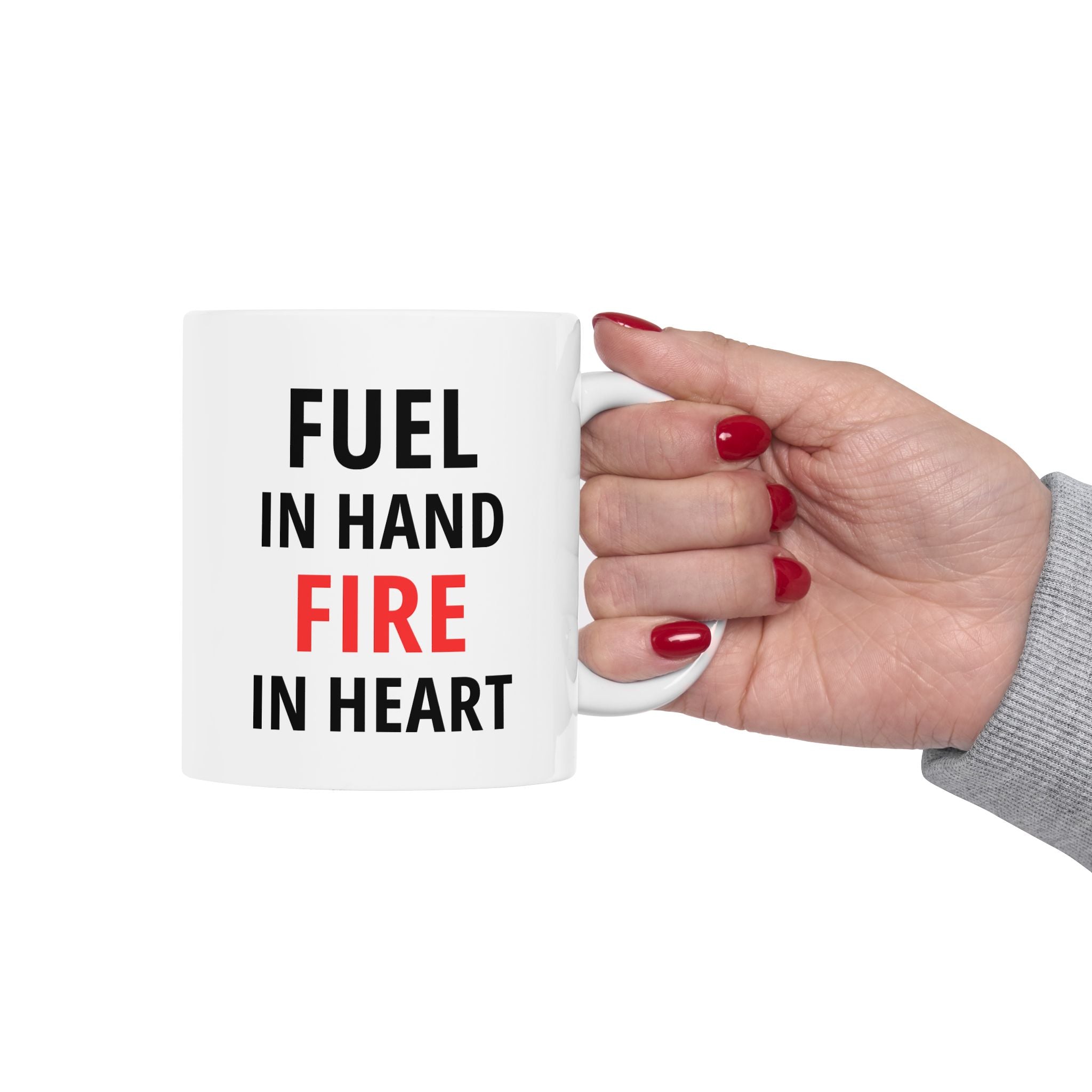 Hand holding a mug with 'FUEL IN HAND FIRE IN HEART' text on a white background
