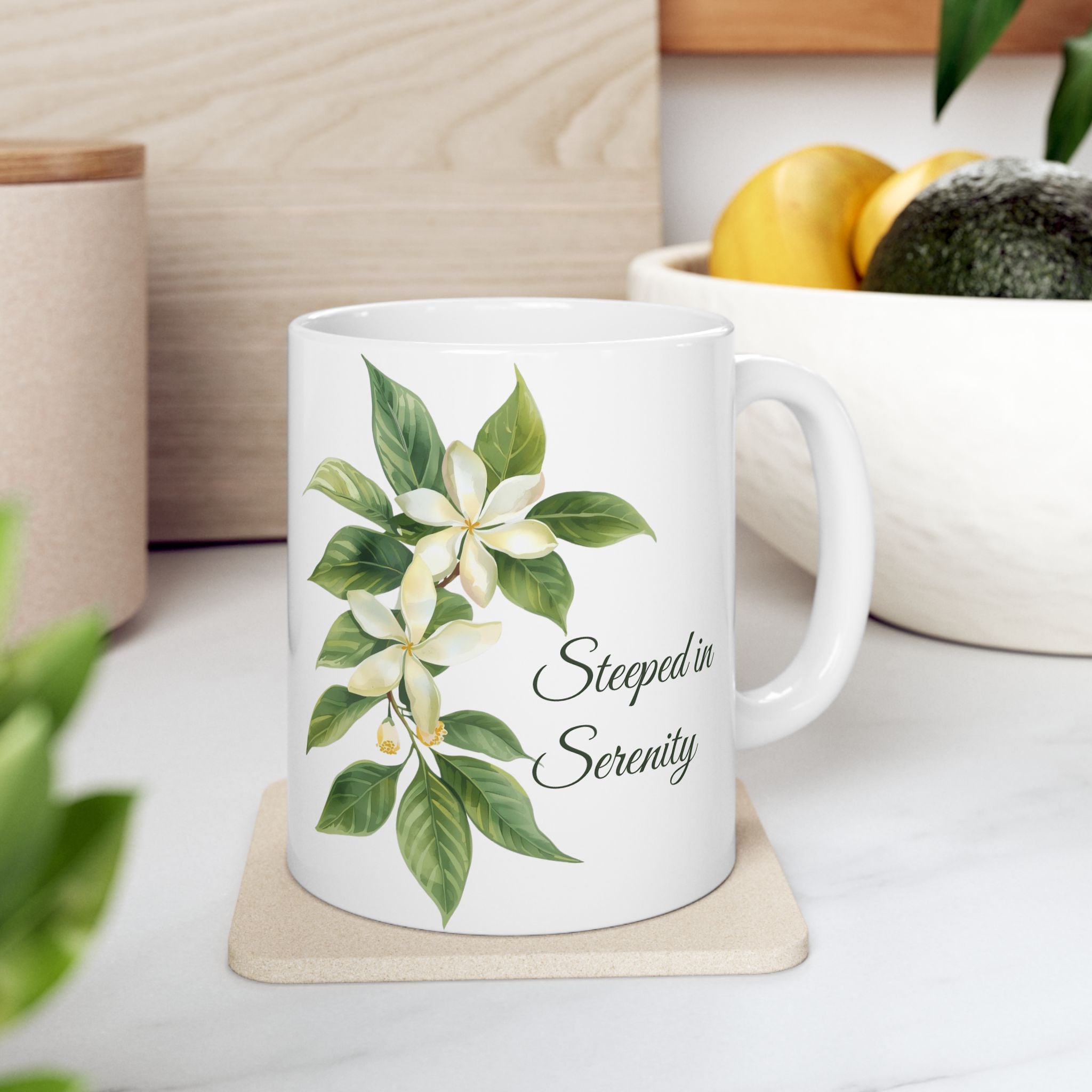 White ceramic mug with jasmine flower design and 'Steeped in Serenity' text on a wooden surface.