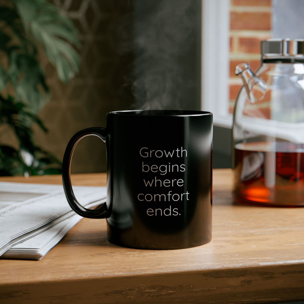 Black mug with motivational quote on a wooden table with a blurred background