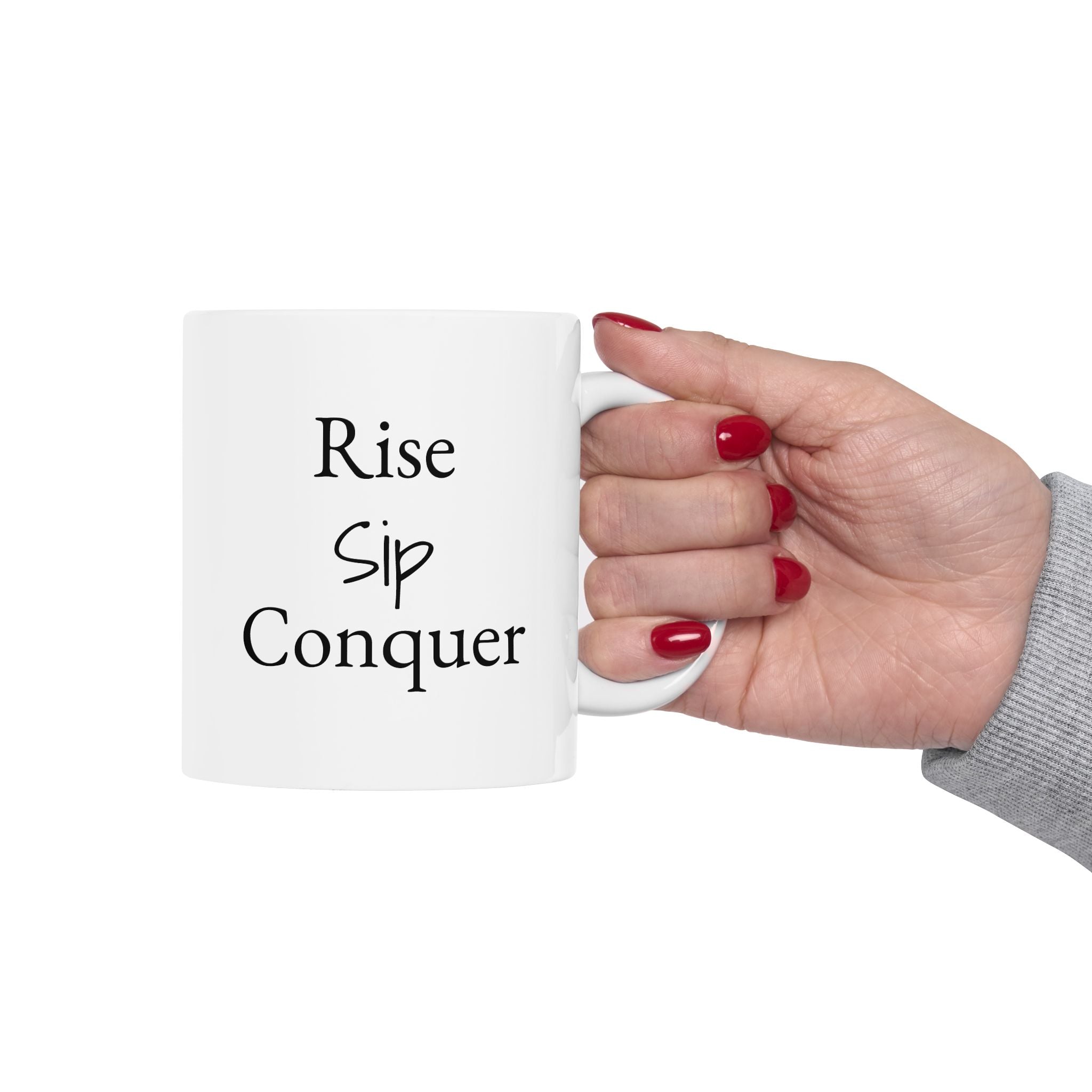 Hand holding a white mug with 'Rise Sip Conquer' text on a white background