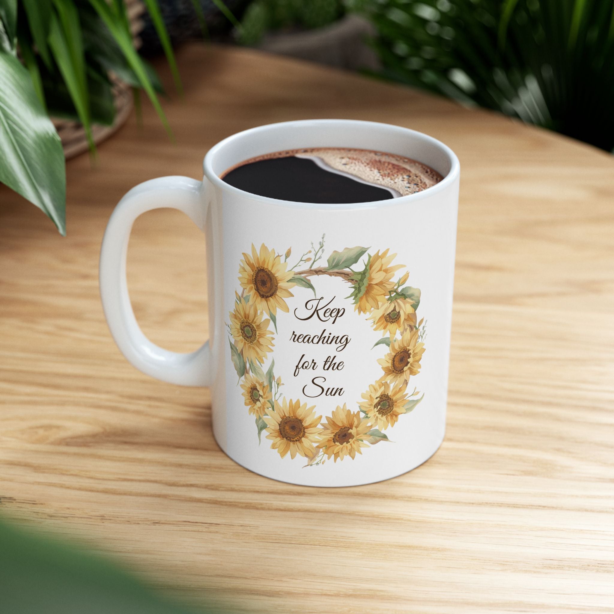 White mug with sunflower design and text on a wooden table