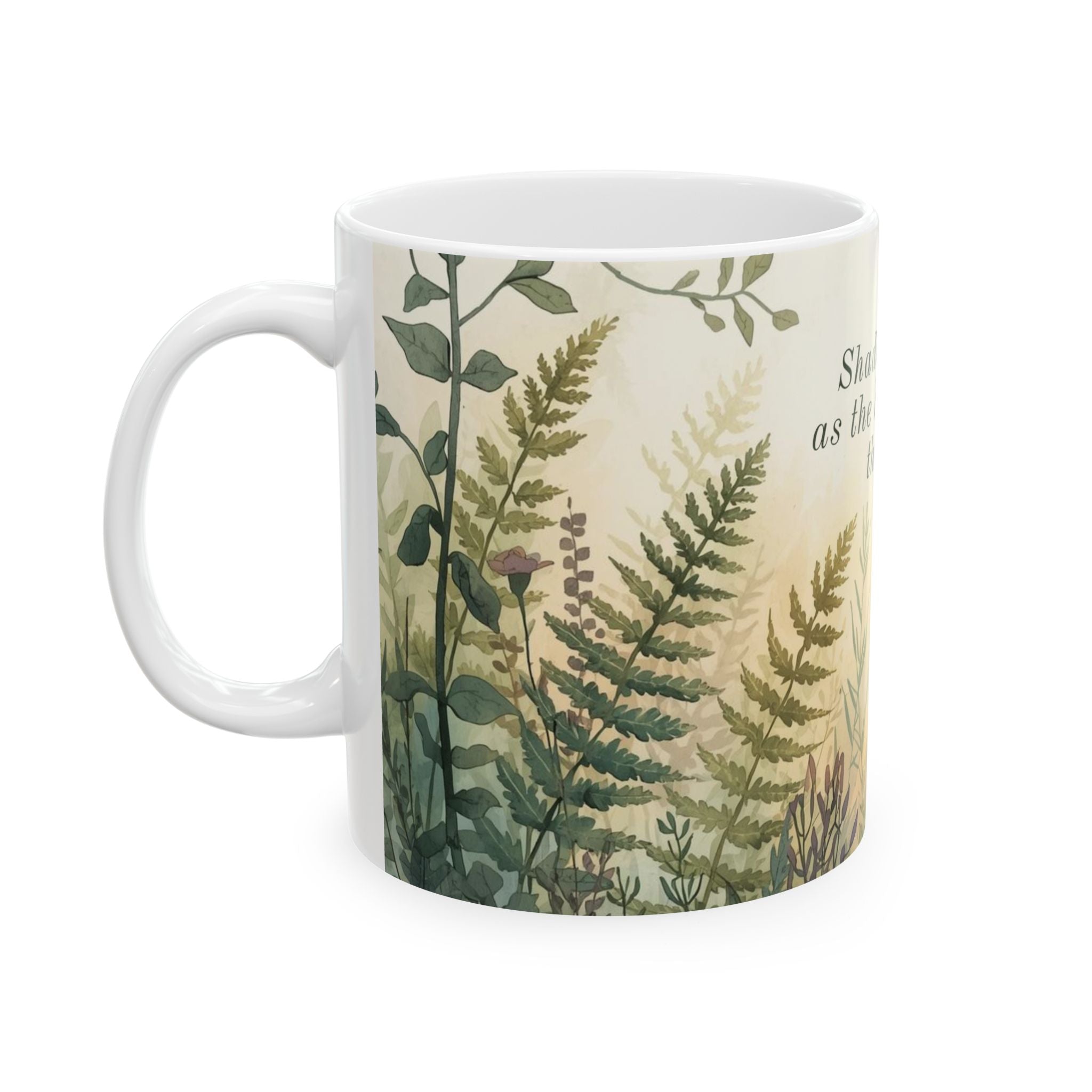 White ceramic mug with green leaf pattern and text 'Shadows fade as the Sun comes through' on a white background