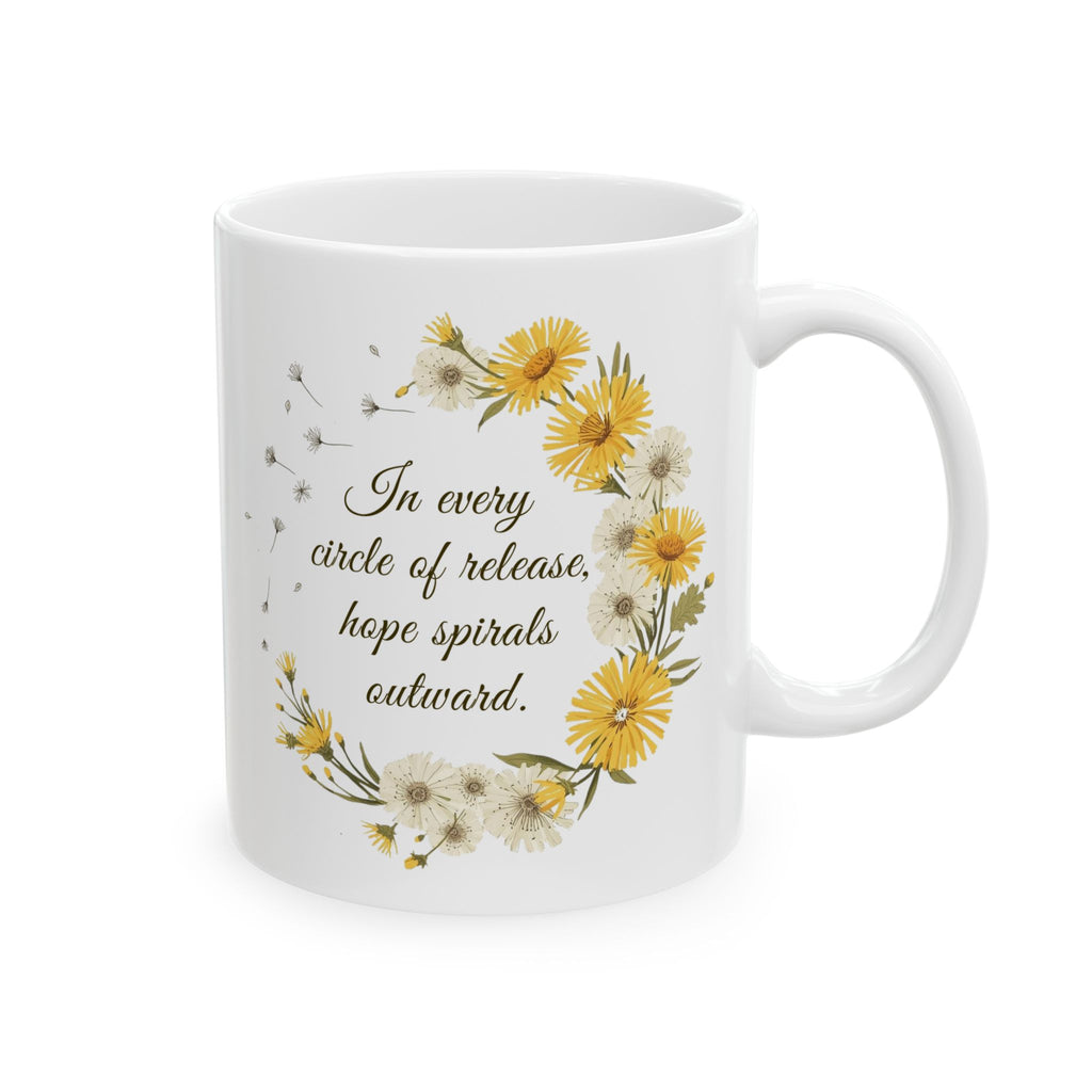 White ceramic mug with dandelion wreath design and motivational quote 'In every circle of release, ope spirals outward.' on a white background