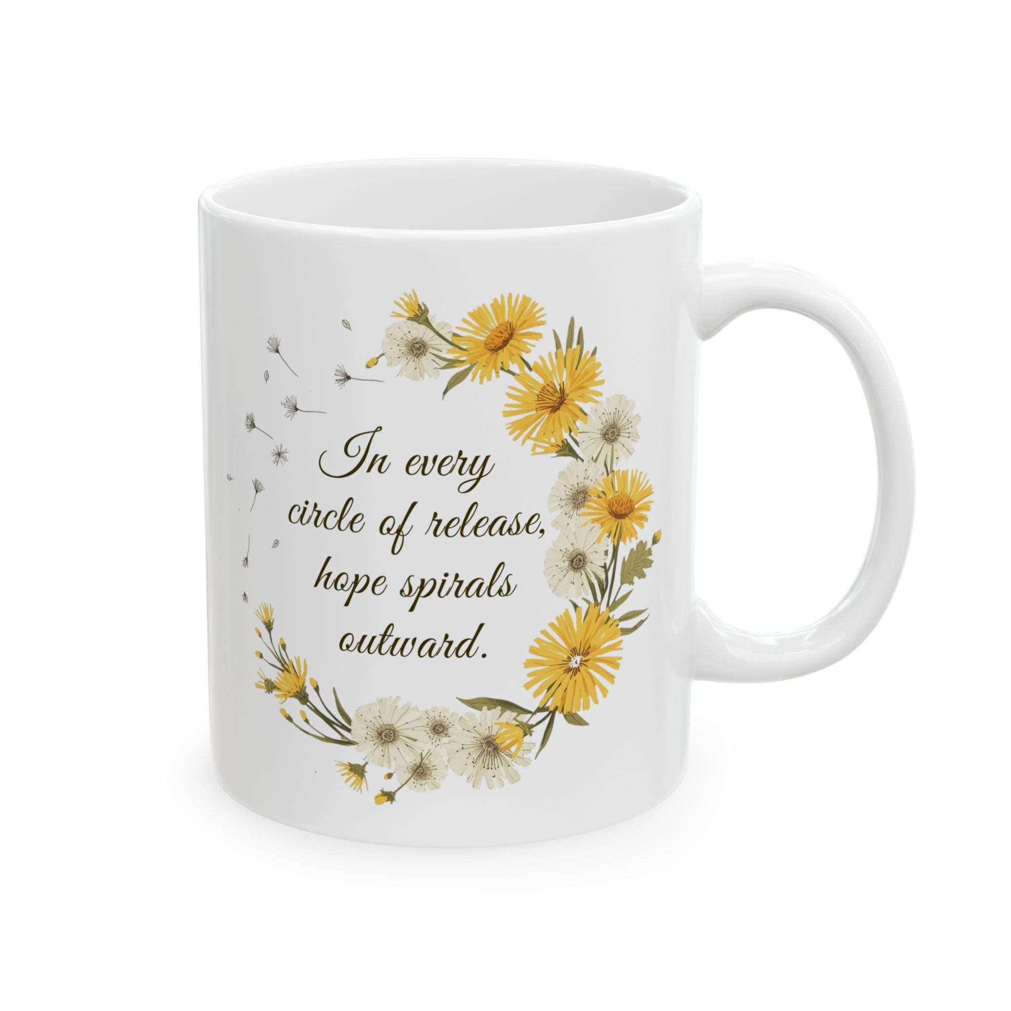 White ceramic mug with dandelion wreath design and motivational quote 'In every circle of release, ope spirals outward.' on a white background