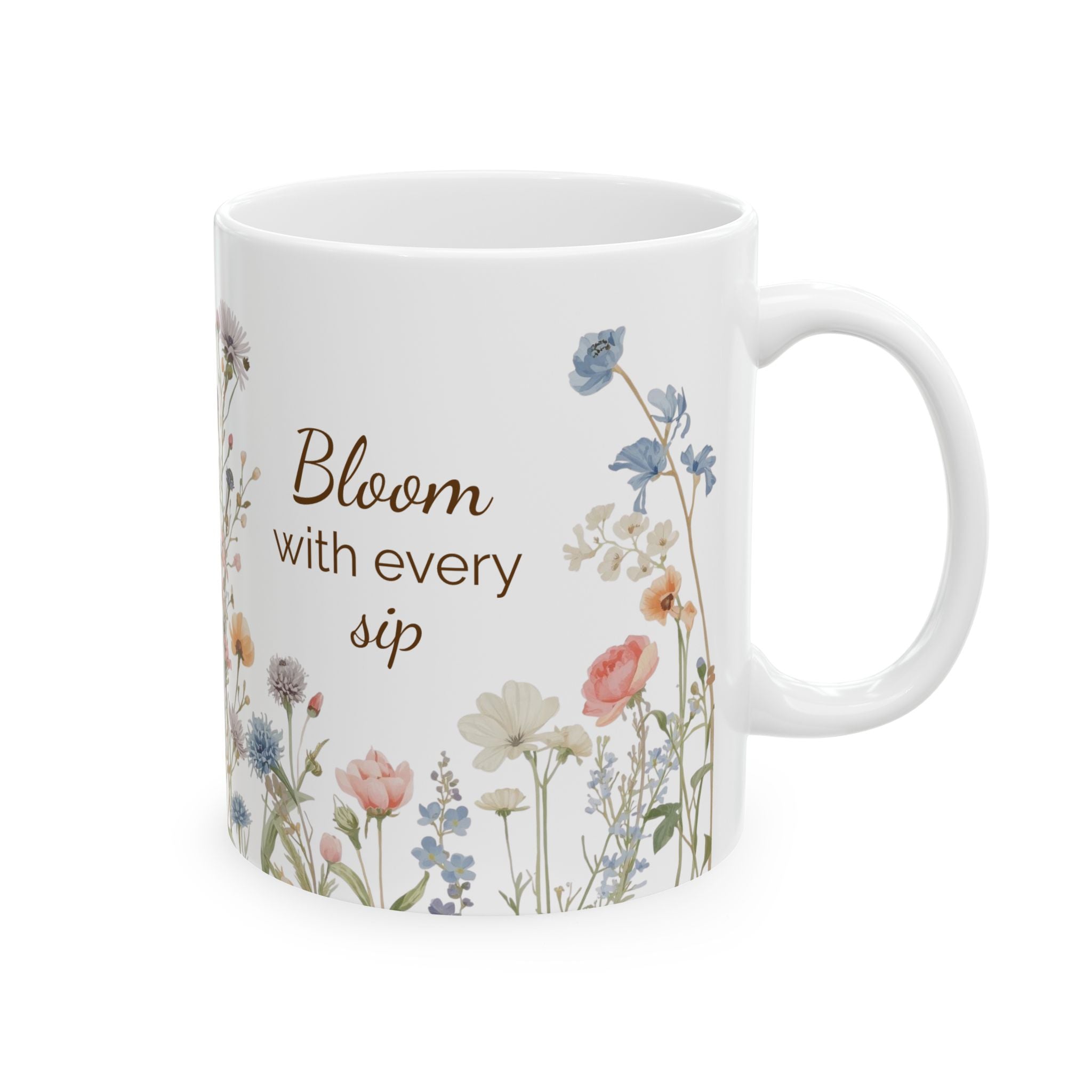 White mug with floral design and text 'Bloom with every sip' on a white background